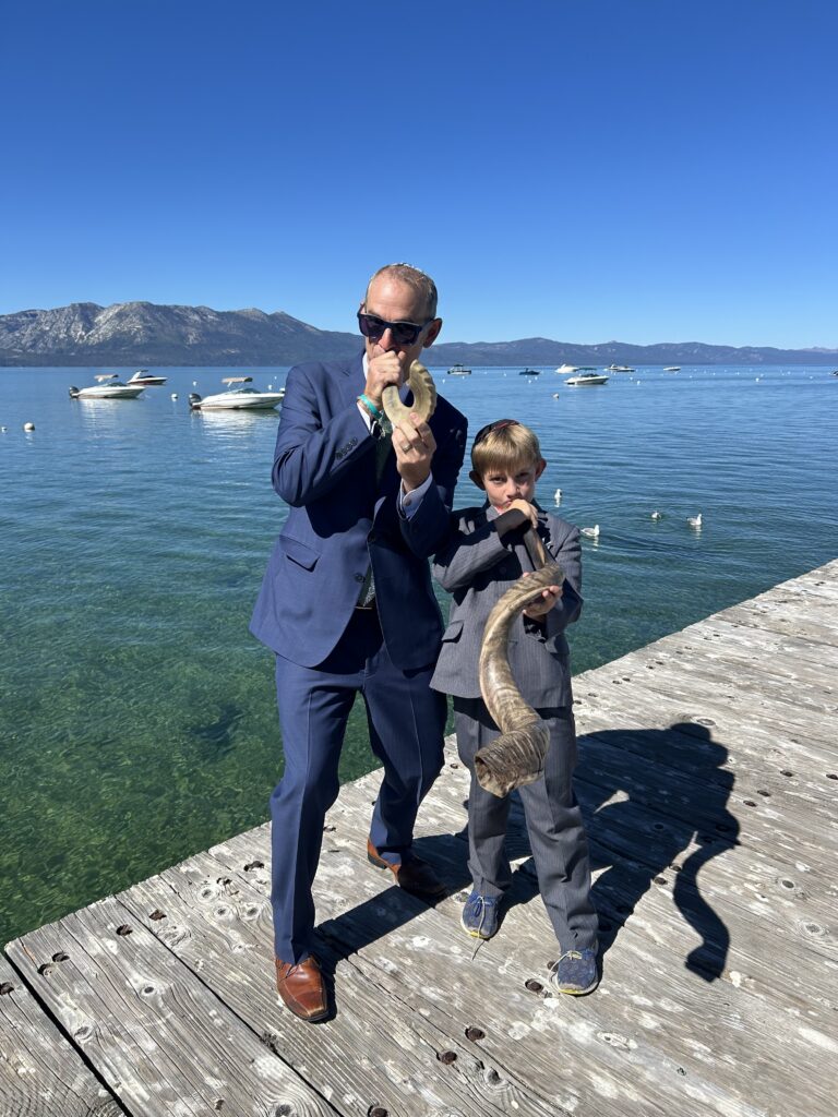 Rabbi Evon blowing the shofar at the Tahoe Jewish Community High Holiday celebration in front of Lake Tahoe.